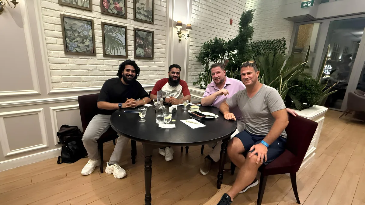 Four men smiling around a table at a restaurant in Dubai